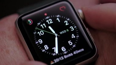 Erkek elinin makro görüntüsü, akıllı bir saat üzerindeki uygulamalardan geçerken. Sığ alan derinliğiyle yakın çekim 