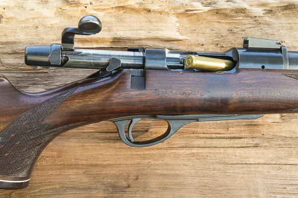 hunting gun with a cartridge on a tree background