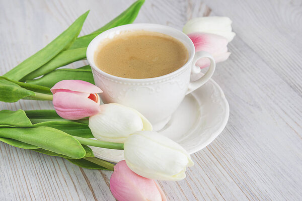 beautiful white cup of beautiful coffee and white and pink tulip