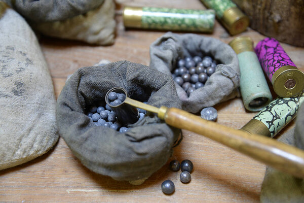 мешки с выстрелами и патроны для охоты на деревянном фоне
