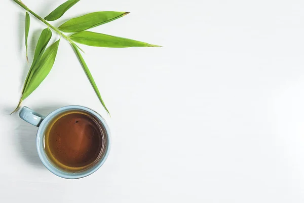 Çay saati konsepti. Bir fincan çay, bambu yaprakları 
