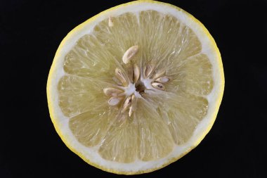 Olgun sulu limon dilimi üst görünümü, siyah arkaplan