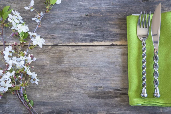 浪漫的餐桌设置 旧木制背景上的樱花枝条和锻造的叉子和刀 — 图库照片