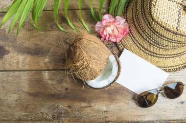 Tropik tatil konsepti. Hasır şapka, hindistan cevizi, güneş gözlüğü, çiçek, boş kağıt