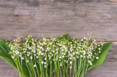 Eski ahşap arka planda vadi zambakları çerçevesi. Metin için boşluk