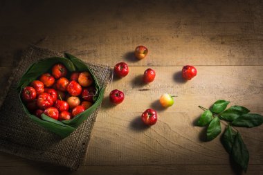 Kahverengi ahşap masa üzerinde bir muz yaprak krathong yerleştirilmiş Tayland kiraz çeşitleri