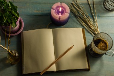 Defter, kalem, kokulu mumlar, temel yağlar, ağaç dalları, tencere, kahve fincan küçük ağaçlar. Ahşap bir masaya