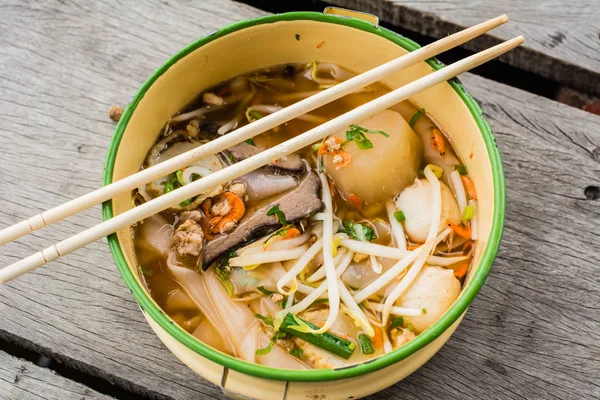 Tom Yam domuz çorbası masada yemek çubukları ile birlikte bir kabın içinde. 