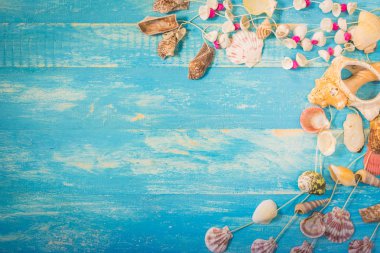 Deniz kabuklarını asılı, birden çok güzel deniz kabuklarını ve mavi ahşap masa üzerinde renkli toplar. 