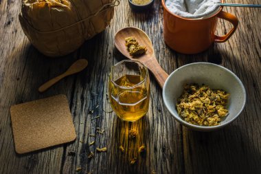 Odak nokta Chrysanthemum çayı ve eski bir ahşap masa üzerinde kurutulmuş papatya. 