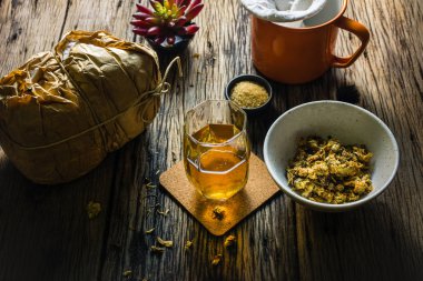 Odak nokta Chrysanthemum çayı ve eski bir ahşap masa üzerinde kurutulmuş papatya. 