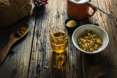 Odak nokta Chrysanthemum çayı ve eski bir ahşap masa üzerinde kurutulmuş papatya. 