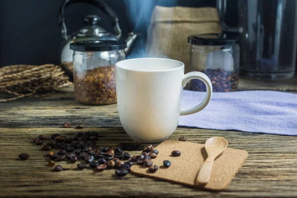 Punto de enfoque, taza de café caliente en la vieja mesa de madera . — Foto de Stock