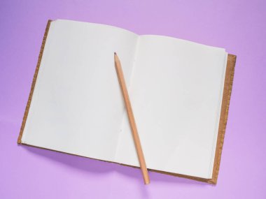 Top view, School notebook on a purple background,  Notebook and pencil on color paper