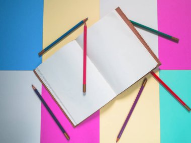 Notebook on a color background and color pencil collection