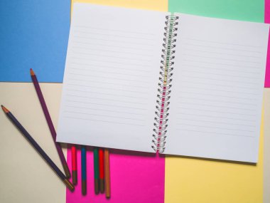 Notebook on a color background and color pencil collection