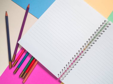 Notebook on a color background and color pencil collection