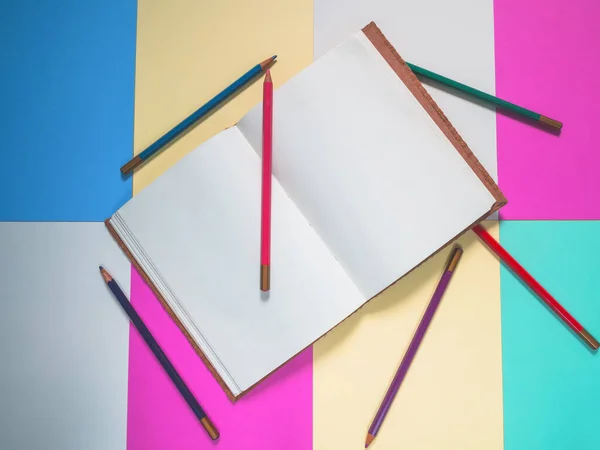Notebook on a color background and color pencil collection