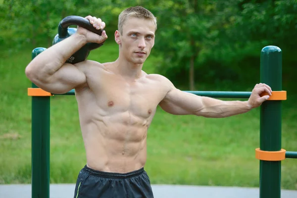 Hombre musculoso practicar entrenamiento callejero en un gimnasio al aire libre —  Fotos de Stock