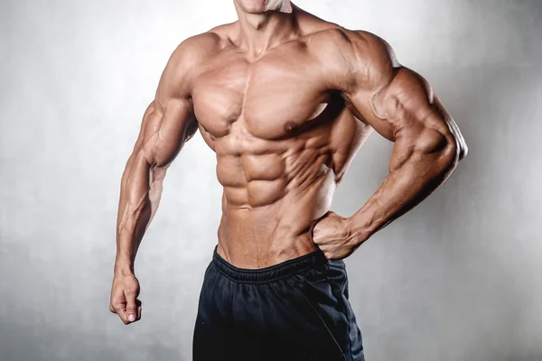 Vahva urheilullinen mies kunto malli osoittaa kuusi pakkaus abs — kuvapankkivalokuva