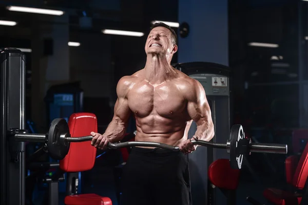 Guapo atlético fitness hombre posando y entrena en el gy —  Fotos de Stock