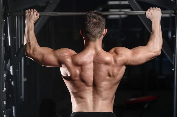 Handsome athletic fitness man posing and trains in the gy — Stock Photo, Image