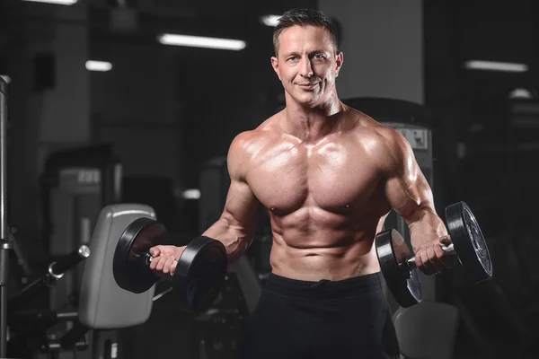 Schöner athletischer Fitnessmann posiert und trainiert im Gym — Stockfoto