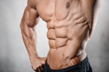 Güçlü atletik erkek fitness modeli gösteren altı bohça abs