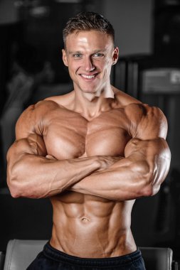 Spor salonunda egzersiz yapan yakışıklı kaslı vücut geliştirmeci erkek