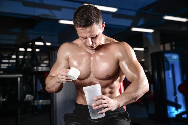 Guapo atlético fitness hombre posando y entrena en el gy — Foto de Stock