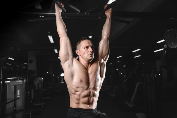 Guapo atlético fitness hombre posando y entrena en el gy —  Fotos de Stock