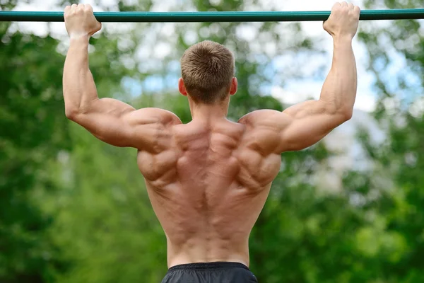 Muskulöse Mann üben Straße Workout in einem Outdoor-Fitnessstudio — Stockfoto