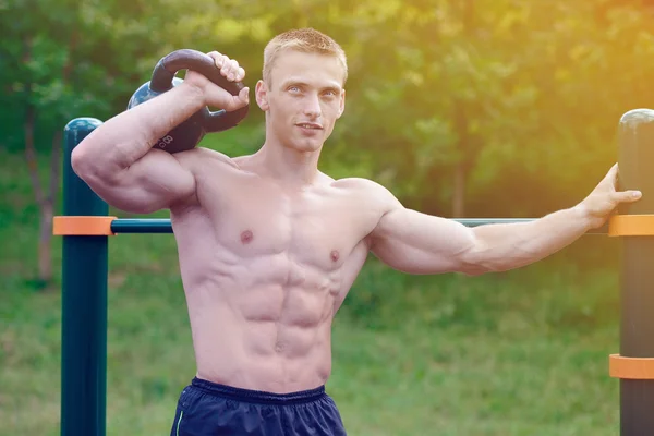 Muskulöse Mann üben Straße Workout in einem Outdoor-Fitnessstudio — Stockfoto