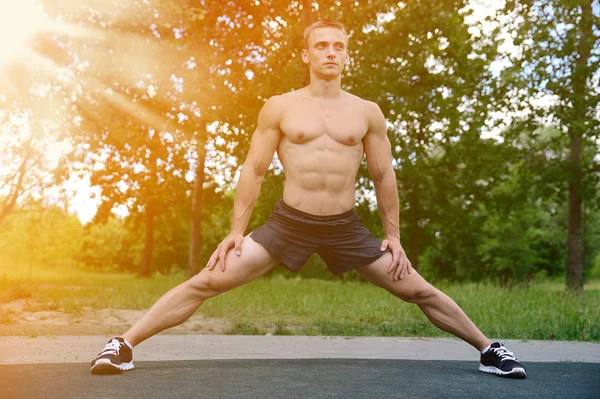 Muskulöse Mann üben Straße Workout in einem Outdoor-Fitnessstudio — Stockfoto