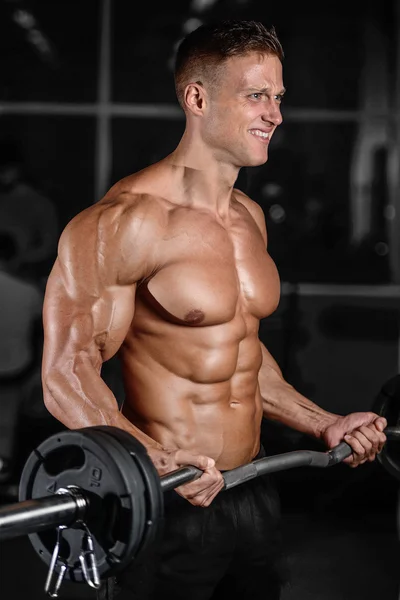 Handsome muscular bodybuilder man doing exercises in gym — Stock Photo, Image