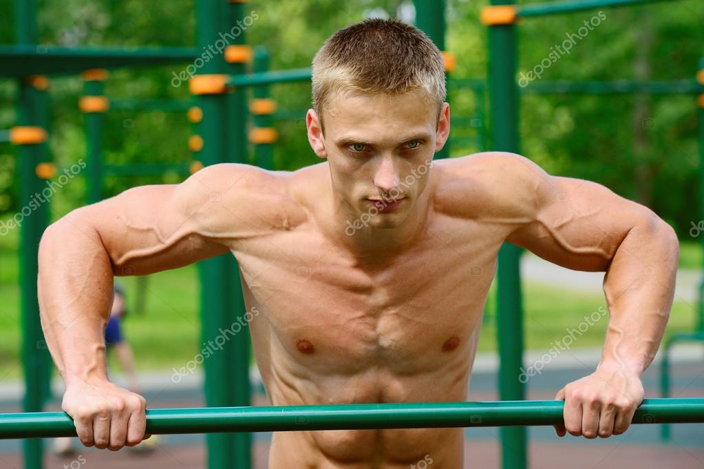 Muscular man practice street workout in an outdoor gym — Stock