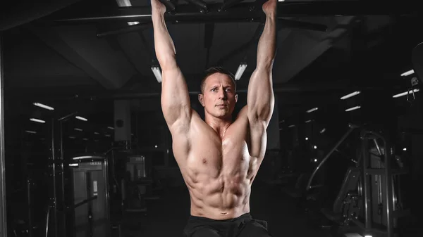 Guapo atlético fitness hombre posando y entrena en el gy —  Fotos de Stock