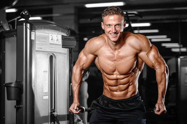 Handsome muscular bodybuilder man doing exercises in gym — Stock Photo, Image