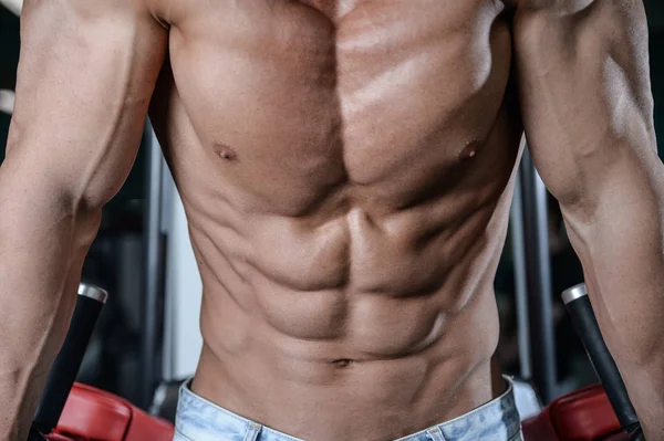 Primer plano fuerte abs chico mostrando en el gimnasio músculos —  Fotos de Stock