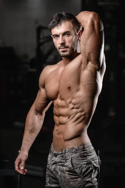 Solide et beau jeune homme athlétique muscles abdominaux et biceps fitness et musculation — Photo