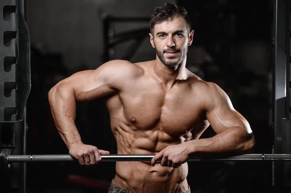 Sterke en knappe sportieve jonge man spieren abs en biceps fitness en bodybuilding — Stockfoto