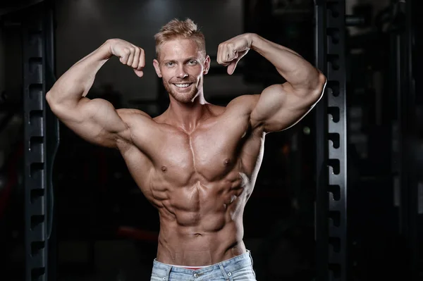Fuerte y guapo atlético jóvenes músculos abdominales y bíceps fitness y culturismo — Foto de Stock