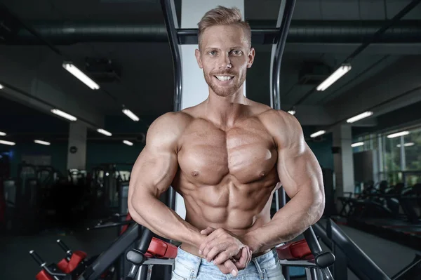 Sterke en knappe sportieve jonge man spieren abs en biceps fitness en bodybuilding — Stockfoto