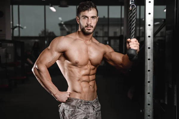 Sterke en knappe sportieve jonge man spieren abs en biceps fitness en bodybuilding — Stockfoto