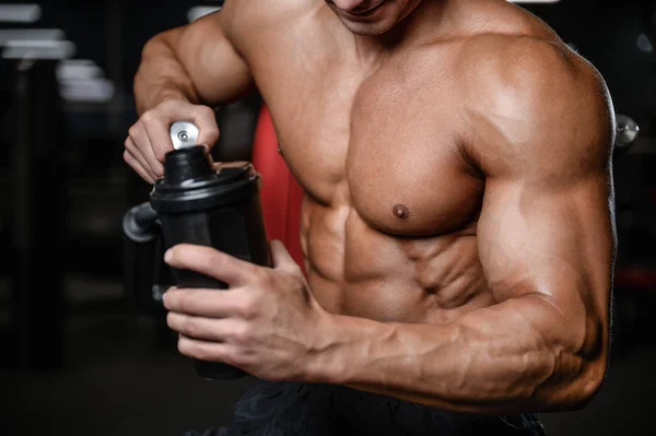 stock image Handsome fitness model holding a shaker in the gym gain muscl