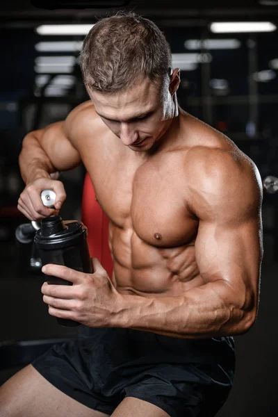 Modelo de fitness guapo sosteniendo un agitador en la ganancia de gimnasio muscl —  Fotos de Stock