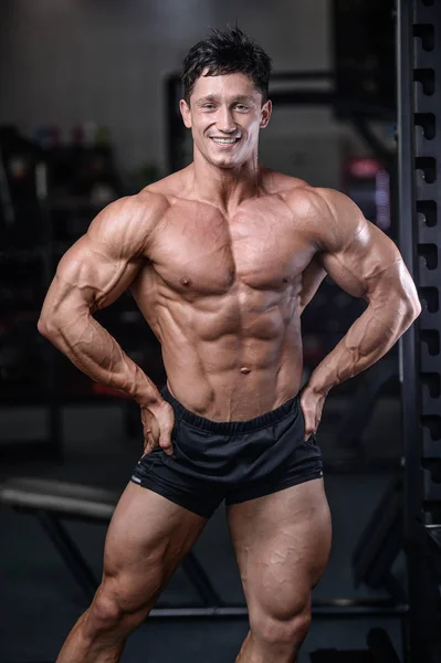 Handsome bodybuilder training in the gym sexy man lift dumbbells — Stock Photo, Image