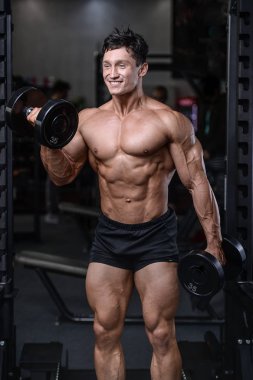 Spor salonu seksi adam Asansör dumbbells eğitim yakışıklı vücut geliştirmeci