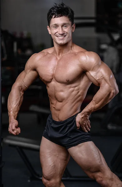 Handsome bodybuilder training in the gym sexy man lift dumbbells — Stock Photo, Image