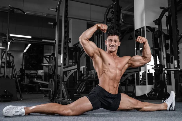 Bölmeleri uzanıyor adam spor salonu yakışıklı fitness bacak germe — Stok fotoğraf
